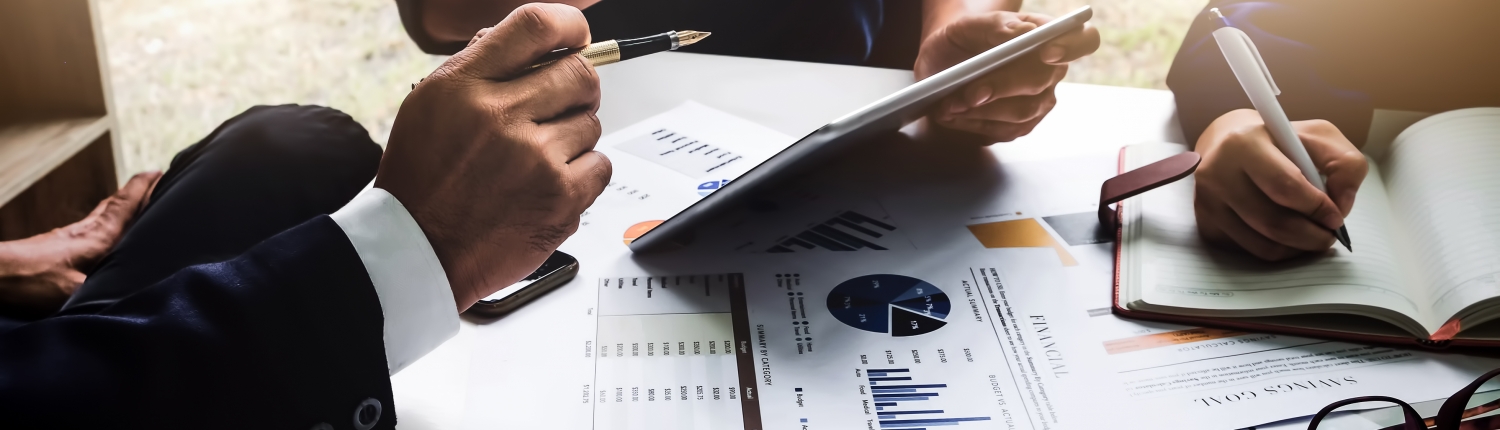 Business people using pen,tablet,notebook are planning a marketing plan to improve the quality of their sales in the future.